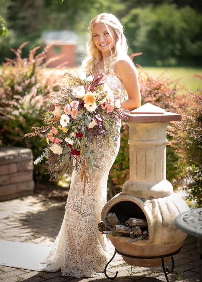 Bride holding a bouquet designed by Pearls & Lace